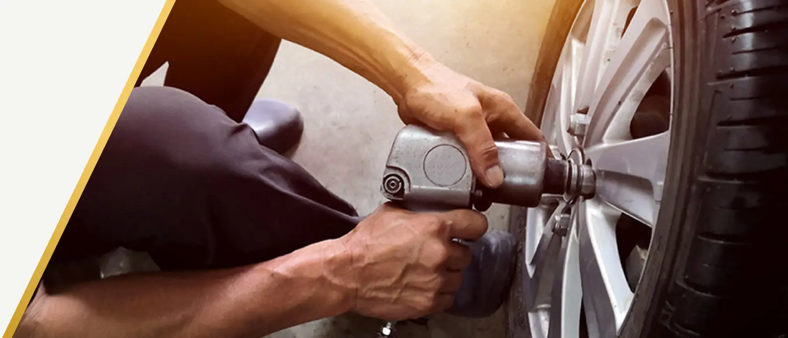 Technician tightening lug nuts with an impact wrench